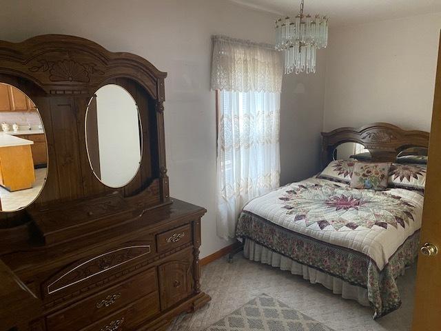 4816 S Harding Ave, Chicago, IL 60632 - bedroom with a notable chandelier and light colored carpet