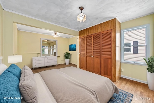 502 Everett Ave, Crystal Lake, IL 60014 - bedroom featuring multiple windows, crown molding, a closet, baseboards, and wood finished floors