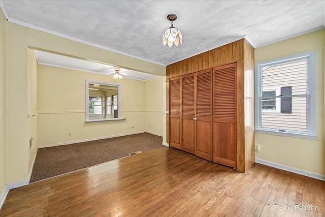 502 Everett Ave, Crystal Lake, IL 60014 - unfurnished bedroom featuring crown molding, a closet, wood-type flooring, and baseboards