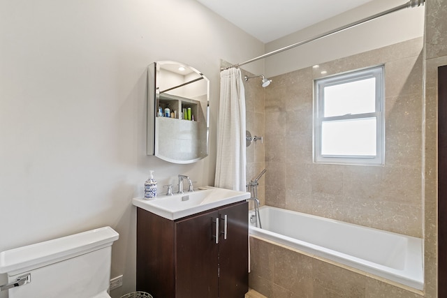 bathroom with tiled shower / bath combo, vanity, and toilet