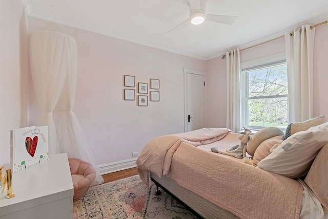 bedroom with crown molding, baseboards, ceiling fan, and wood finished floors