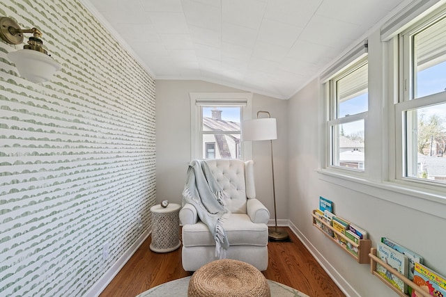 living area with wallpapered walls, a healthy amount of sunlight, baseboards, and an accent wall