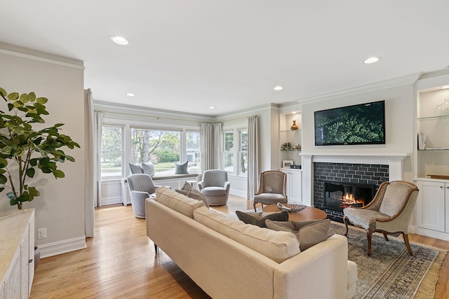 living area featuring recessed lighting, light wood-style floors, ornamental molding, and a tile fireplace