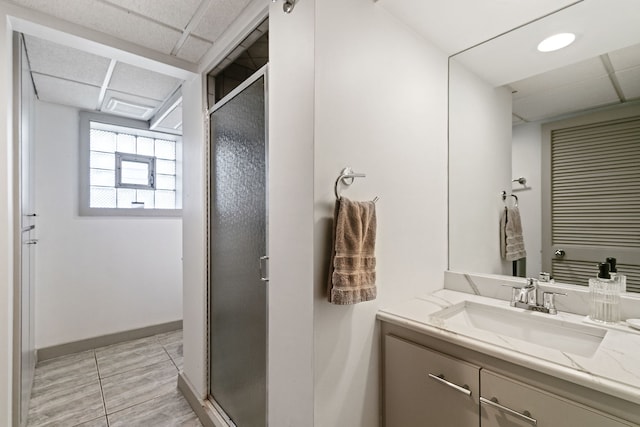bathroom with vanity, baseboards, and a stall shower