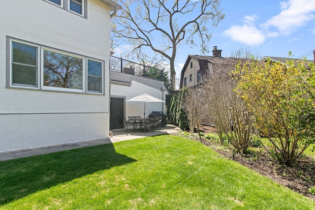 view of yard featuring a patio, fence, and a balcony