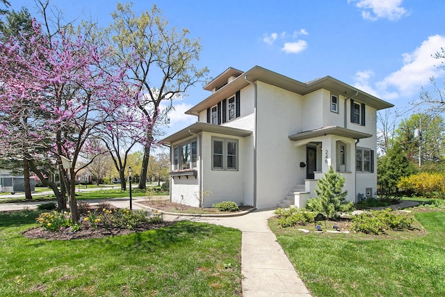 prairie-style house featuring stucco siding and a front lawn