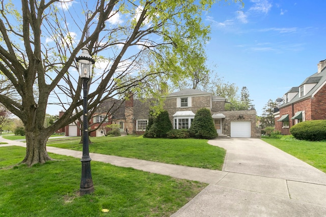 traditional home with concrete driveway, an attached garage, stone siding, and a front lawn