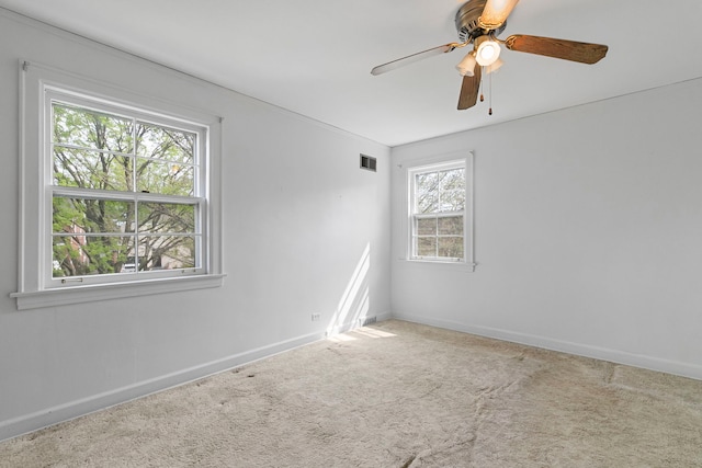 spare room featuring baseboards, ceiling fan, carpet floors, and visible vents