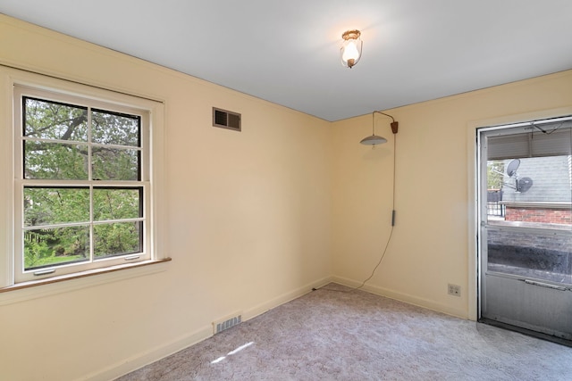 empty room with visible vents, baseboards, and plenty of natural light