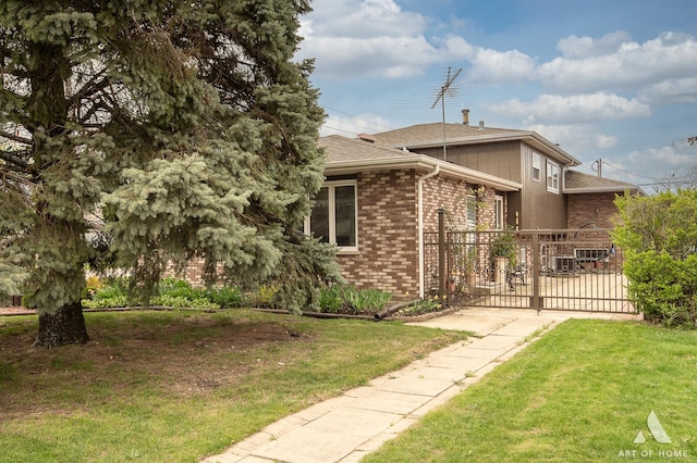 view of property exterior featuring fence, a yard, a shingled roof, and brick siding