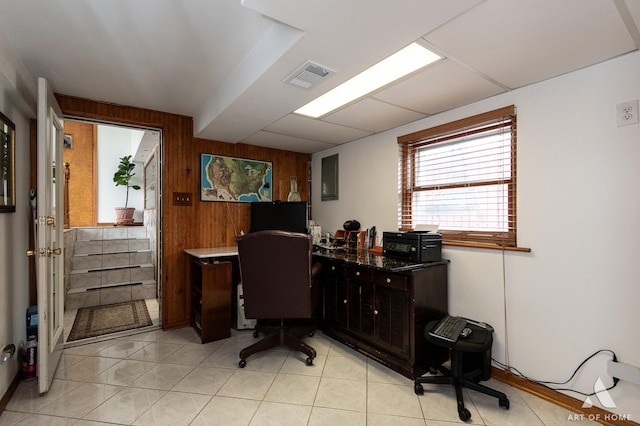 home office with wood walls, light tile patterned floors, and visible vents