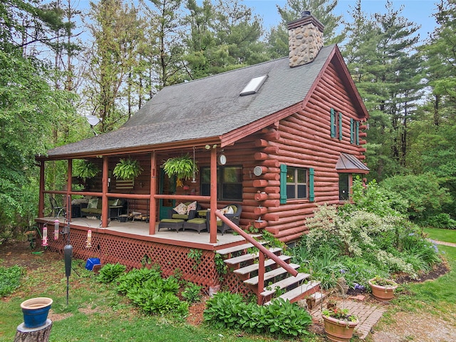 25561 S Pinewood Ln, Monee, IL 60449 - log cabin featuring log exterior, a chimney, a shingled roof, and a wooden deck