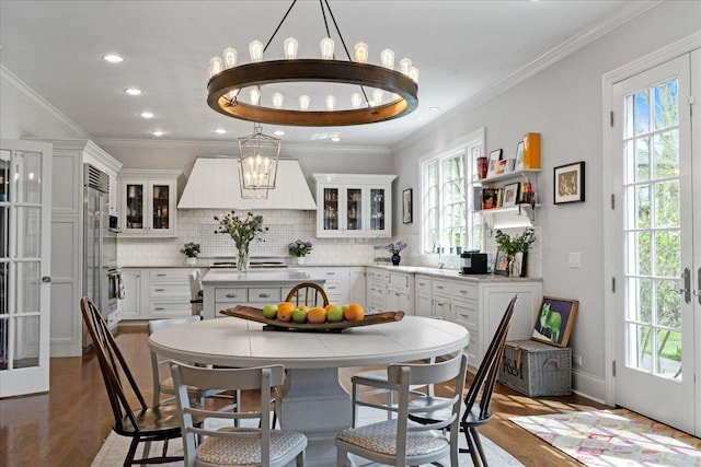 dining room featuring a chandelier, ornamental molding, french doors, and wood finished floors