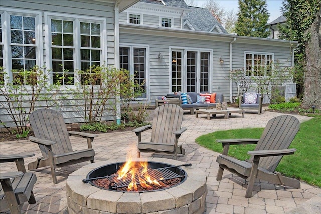 view of patio with an outdoor living space with a fire pit