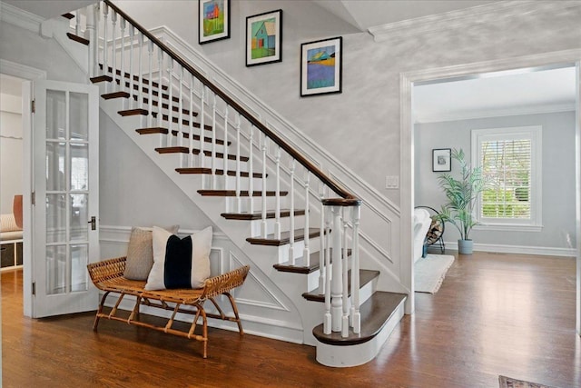 stairway with crown molding, baseboards, and wood finished floors