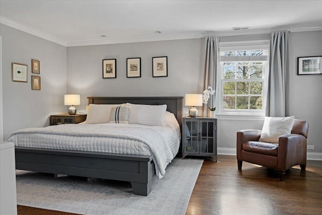 bedroom with baseboards, ornamental molding, and wood finished floors