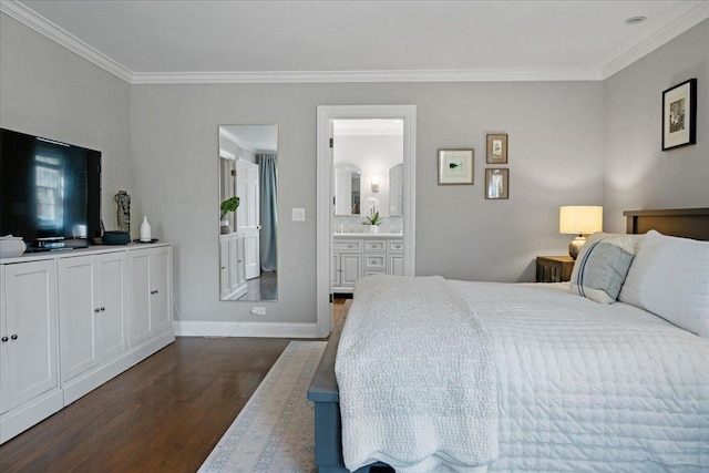 bedroom with crown molding, baseboards, dark wood finished floors, and ensuite bath