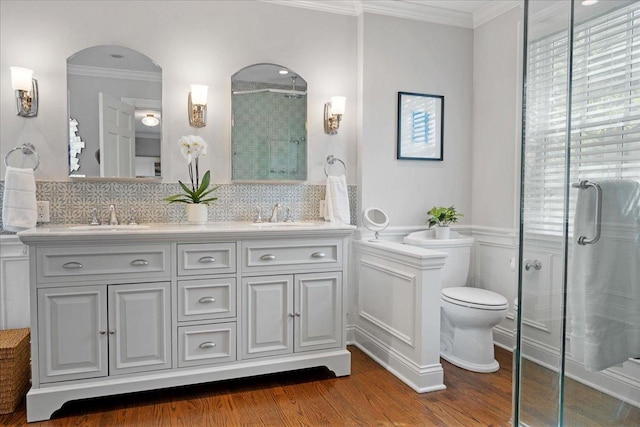 full bathroom featuring a sink, crown molding, a stall shower, and wood finished floors