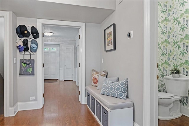 hallway with baseboards and wood finished floors