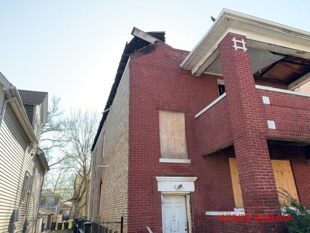 view of home's exterior with fence and brick siding