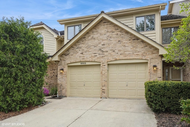 view of front facade featuring brick siding, a garage, and driveway