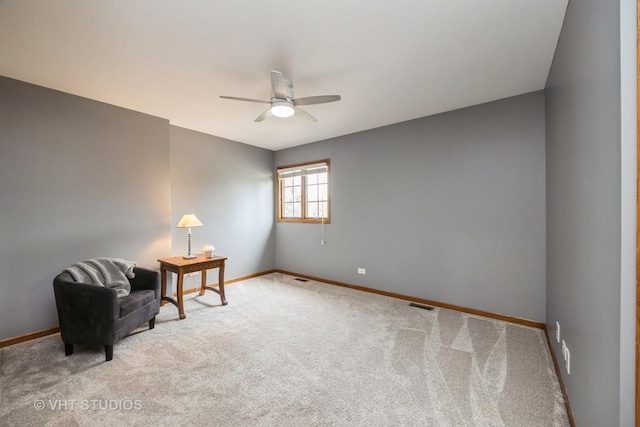 living area with carpet floors, a ceiling fan, and baseboards