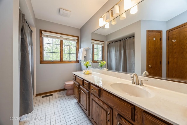 bathroom featuring visible vents, vanity, baseboards, tile patterned floors, and toilet