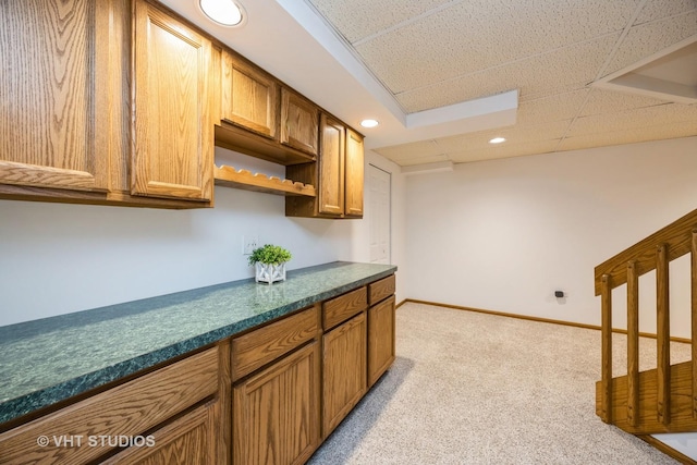 kitchen featuring open shelves, dark countertops, light colored carpet, recessed lighting, and brown cabinets