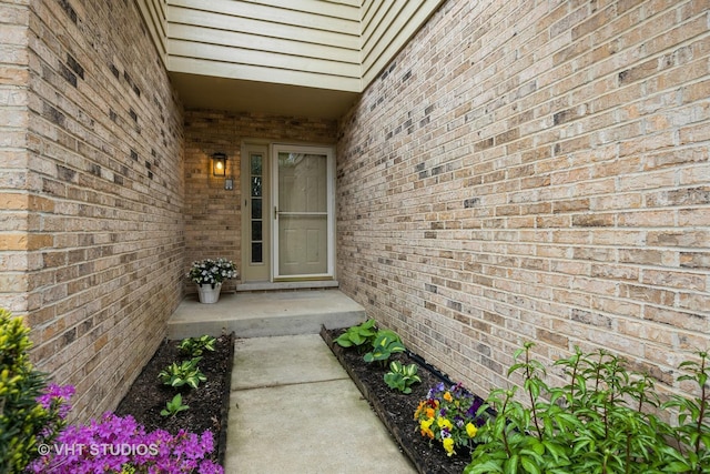 view of exterior entry featuring brick siding