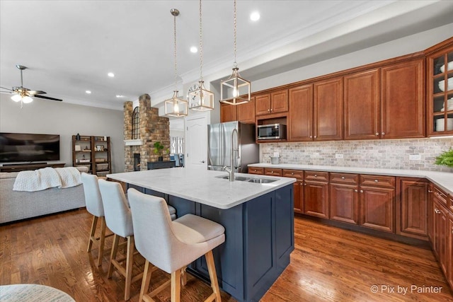 kitchen featuring crown molding, open floor plan, a breakfast bar area, backsplash, and stainless steel appliances