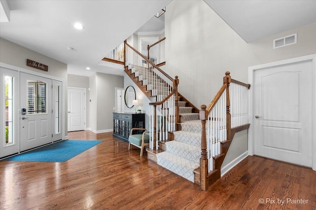 entryway featuring visible vents, wood finished floors, baseboards, stairway, and recessed lighting