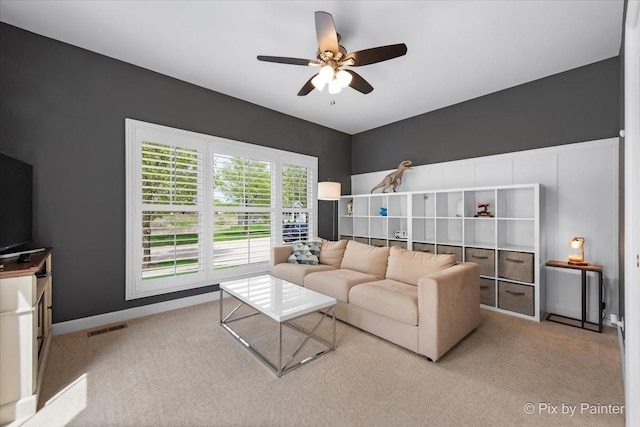 living room featuring carpet floors, ceiling fan, baseboards, and visible vents