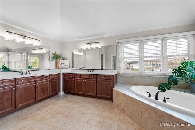 bathroom featuring a sink, tile patterned flooring, a garden tub, and two vanities
