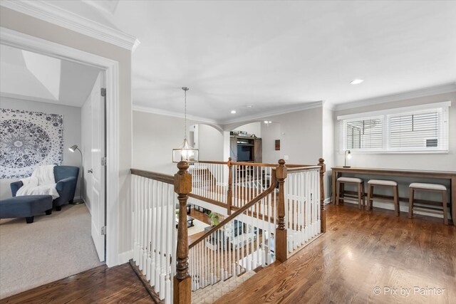 corridor featuring recessed lighting, baseboards, an upstairs landing, wood finished floors, and ornamental molding