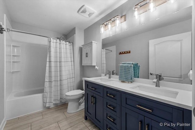 full bathroom featuring double vanity, toilet, visible vents, and a sink