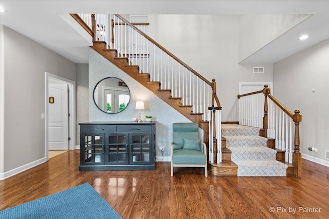stairway with recessed lighting, baseboards, visible vents, and wood finished floors