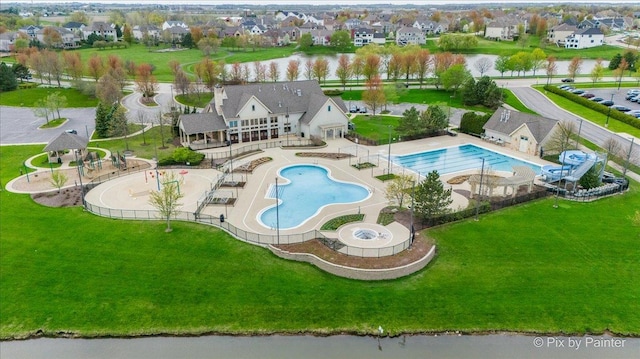 pool featuring a patio area, a yard, and a residential view