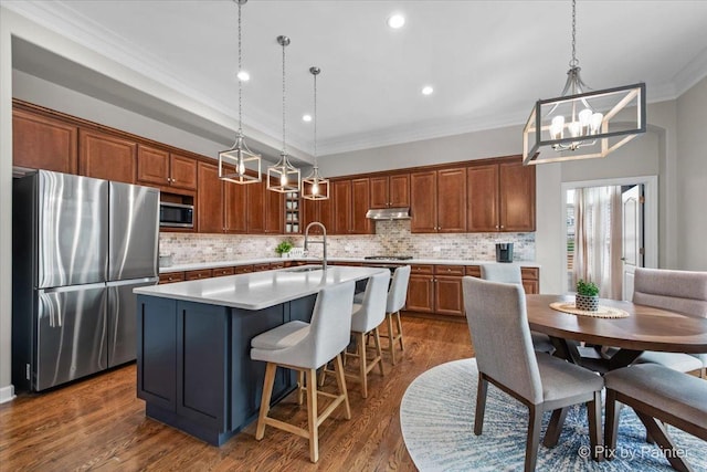 kitchen featuring crown molding, an inviting chandelier, tasteful backsplash, a sink, and appliances with stainless steel finishes