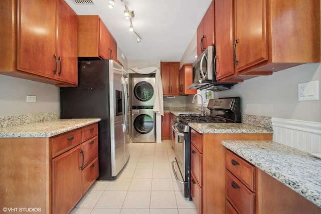 444 Winnetka Ave, Winnetka, IL 60093 - kitchen with stacked washer / drying machine, stainless steel appliances, brown cabinetry, and wainscoting
