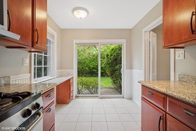 444 Winnetka Ave, Winnetka, IL 60093 - kitchen featuring wainscoting, plenty of natural light, light tile patterned floors, light stone counters, and stainless steel gas range