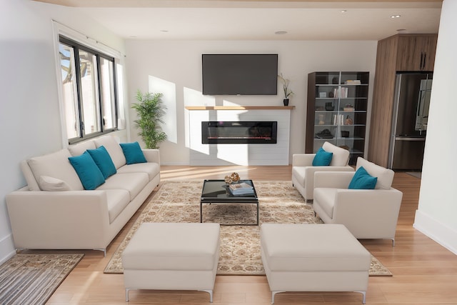 living area with light wood-style floors, recessed lighting, baseboards, and a glass covered fireplace