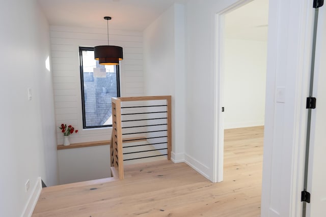 hall with baseboards and wood finished floors