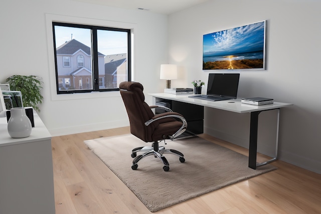 office featuring baseboards and light wood-style flooring
