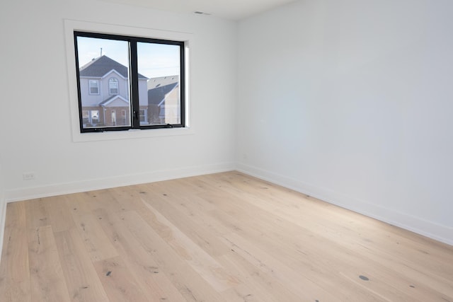 empty room featuring baseboards and wood-type flooring