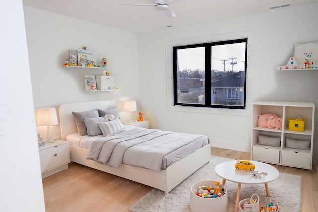 bedroom featuring visible vents, a ceiling fan, and light wood-style floors