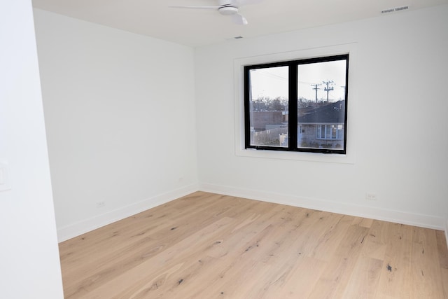 unfurnished room with visible vents, a ceiling fan, baseboards, and wood finished floors
