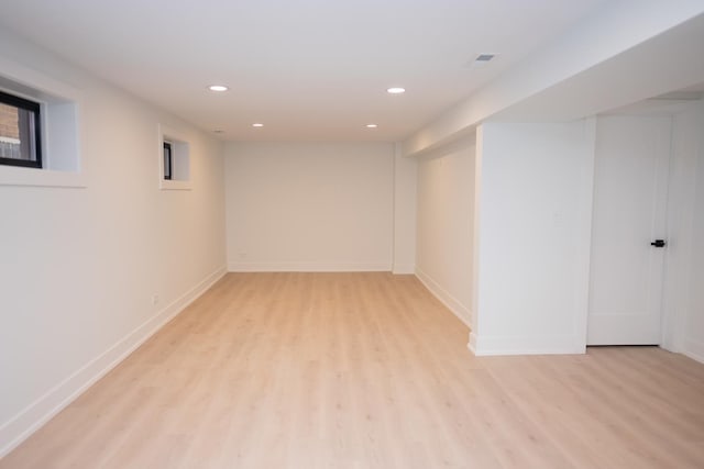 finished basement featuring recessed lighting, baseboards, visible vents, and light wood-style flooring