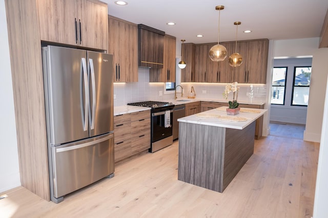 kitchen featuring a sink, light wood-style flooring, appliances with stainless steel finishes, and modern cabinets