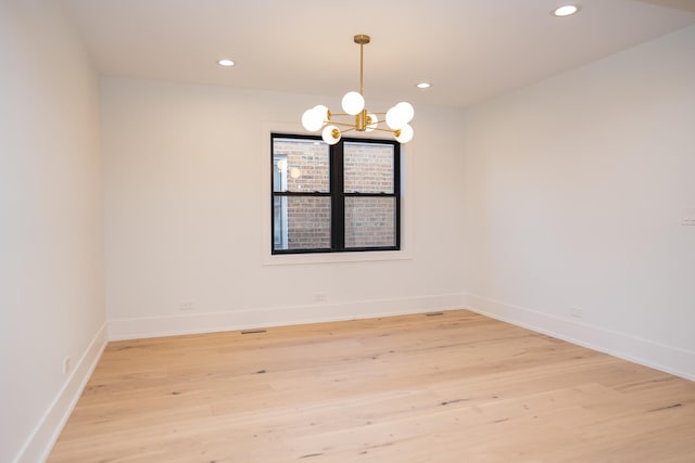 spare room featuring light wood-style floors, recessed lighting, baseboards, and a chandelier