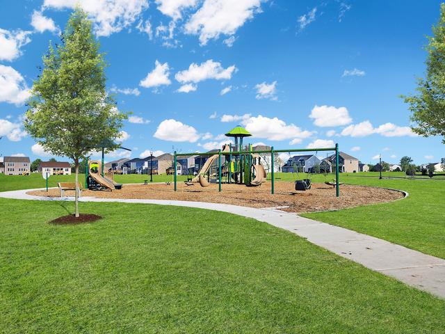 community playground featuring a lawn and a residential view